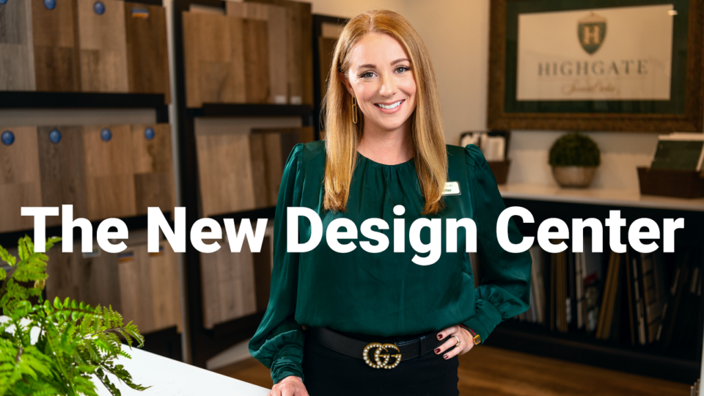 A smiling woman in a green blouse stands in a design center with shelves of samples in the background, with text overlay saying "the new design center.