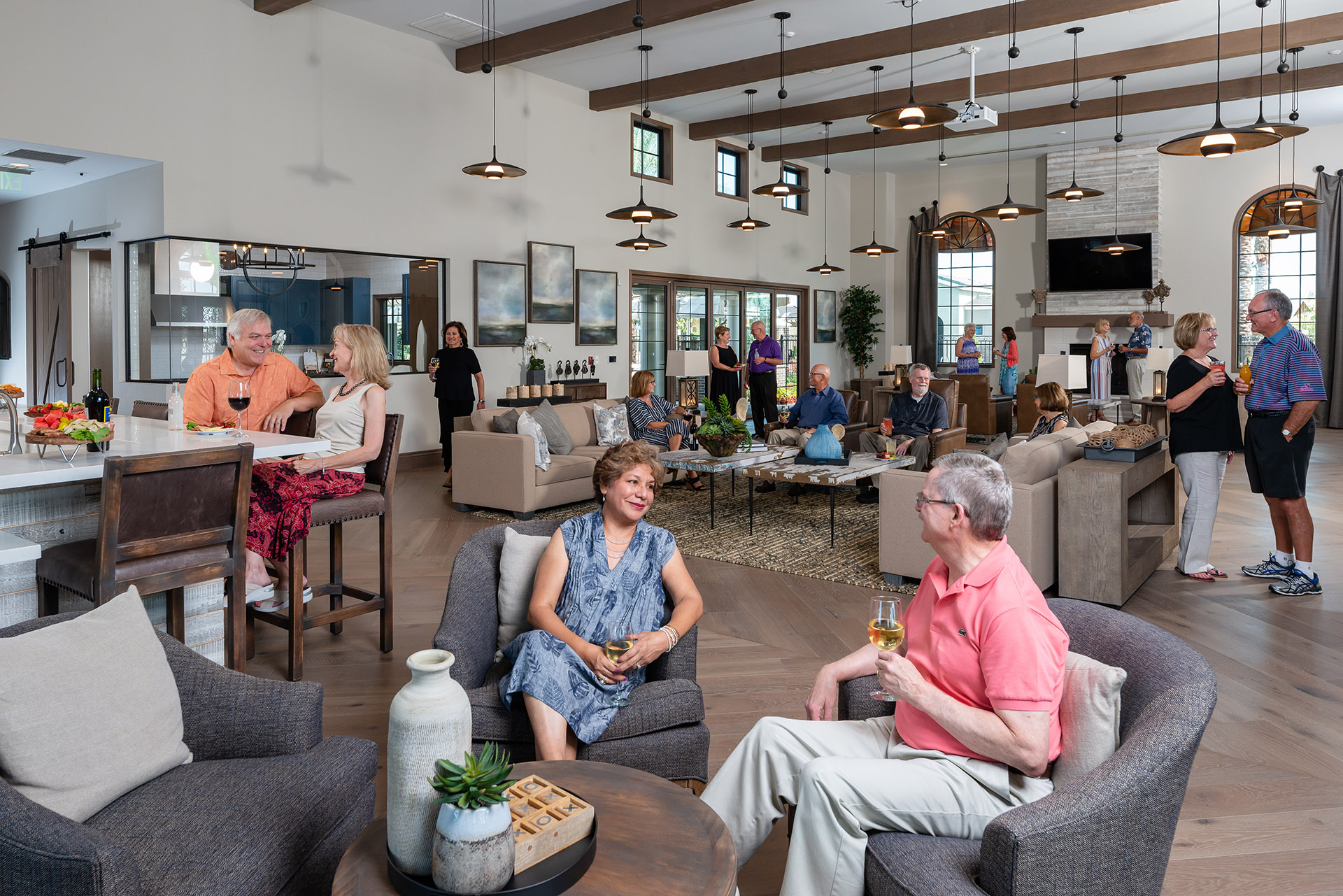 A lively communal space with several senior adults engaging in conversation. some stand by a bar, while others sit on sofas and chairs, chatting and enjoying drinks. the room features a modern, cozy décor.