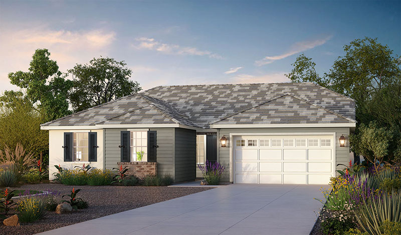 Single-story modern house with gray siding, white trim, and a two-car garage. The front yard has desert landscaping with rocks and drought-tolerant plants. The driveway is wide and smooth, and the sky is clear with soft clouds.