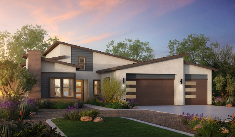 Modern single-story house with a mix of white and dark siding, large windows, and a double garage at sunset. The yard features desert landscaping with rocks and native plants.